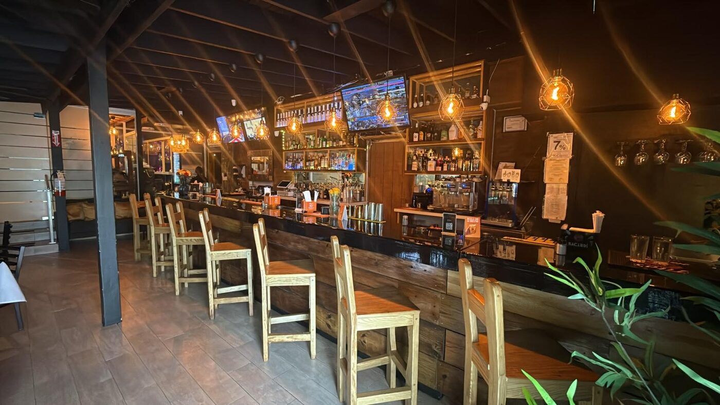 Barra principal de La Nueva Cobacha con coctelería, rones y cervezas frías